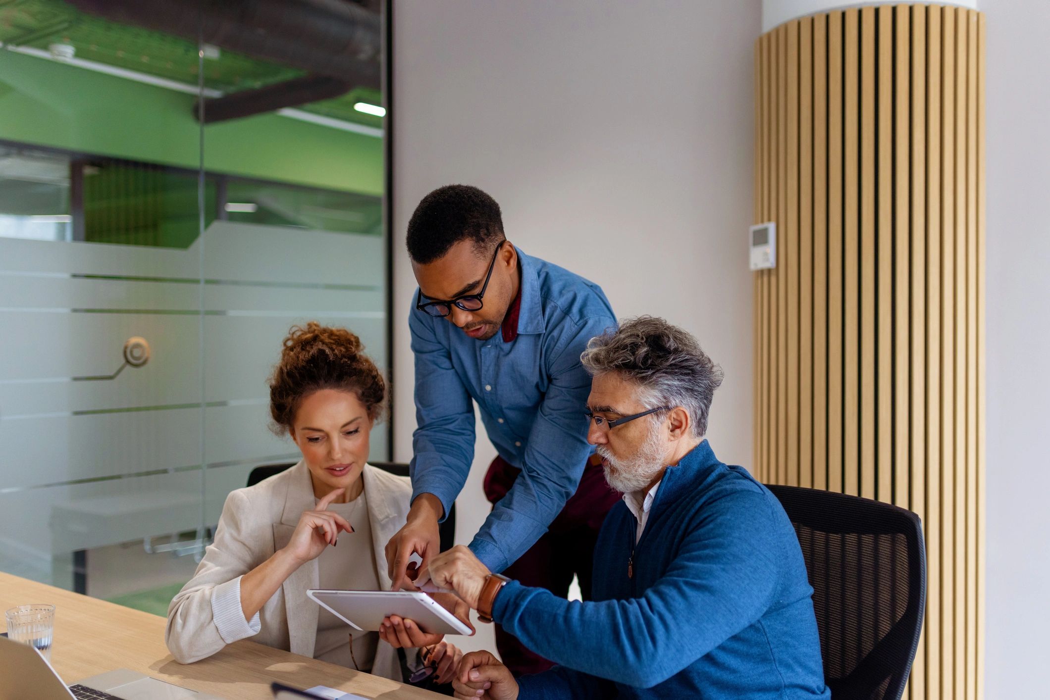 Business professionals collaborating on a tablet in an office
