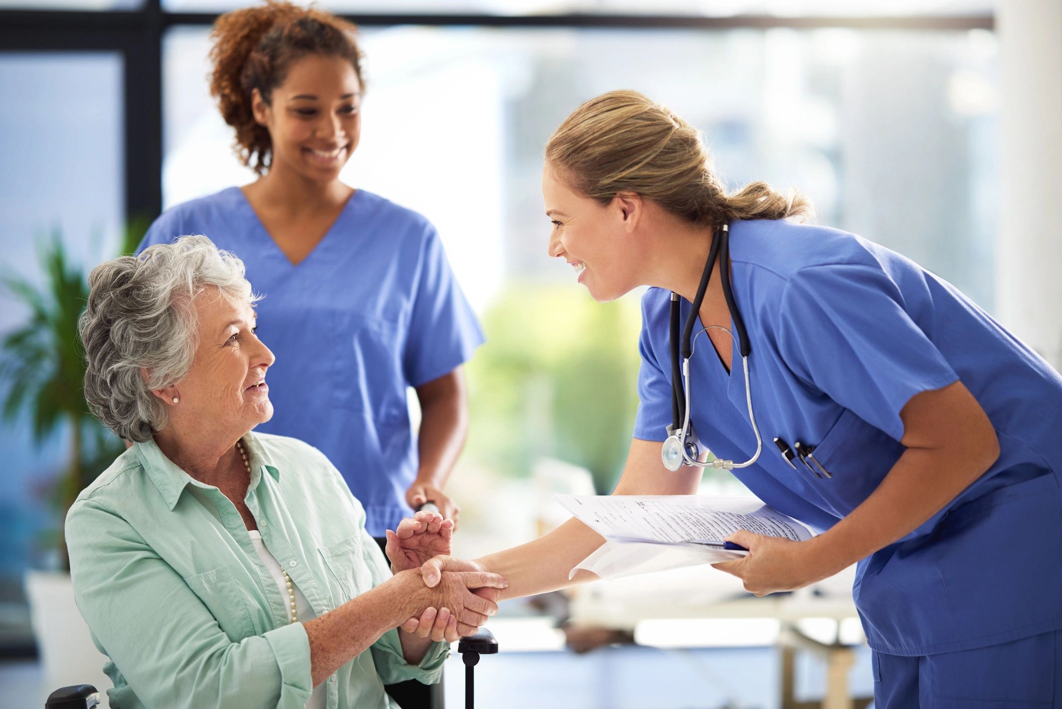Doctor greeting a senior patient with medical records in hand
